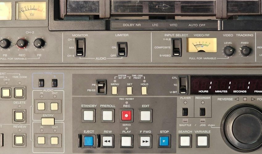 Professional rack-mounted Betacam and U-matic videocassette recorders with playback controls, transport buttons, VU meters, and timecode readouts used for broadcast-quality tape transfer