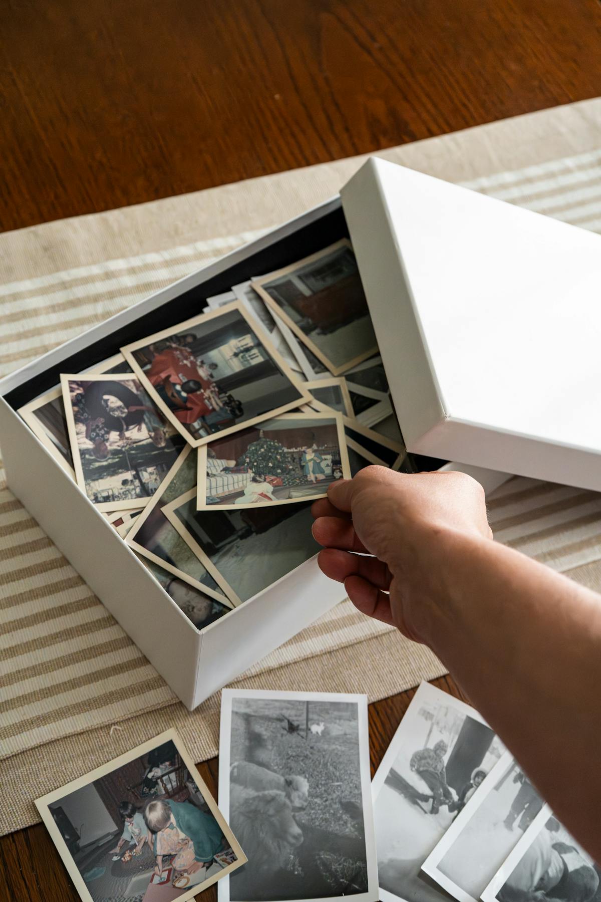 A family sorting through inherited old photographs and memories spread across a table