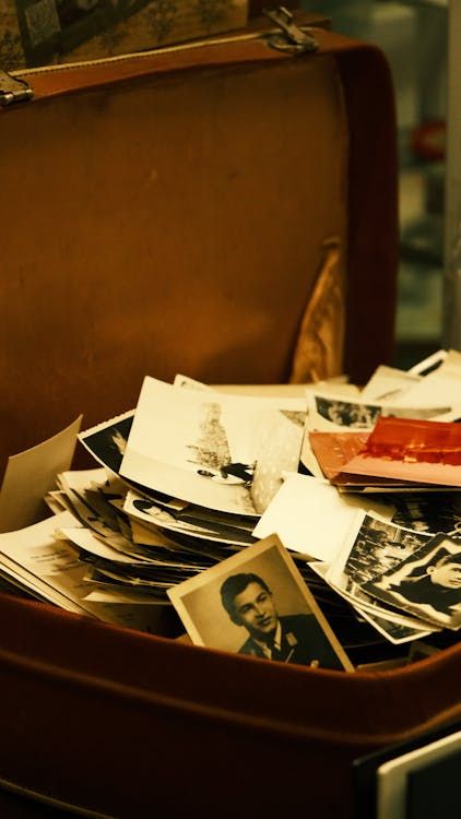 Collection of nostalgic black and white photographs stored in a vintage suitcase awaiting photo scanning