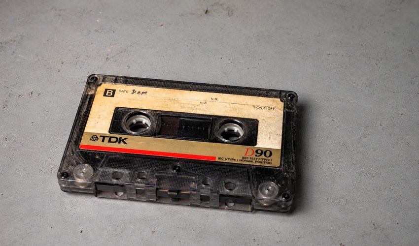 Close-up of reel-to-reel audio tape threaded on a professional playback deck