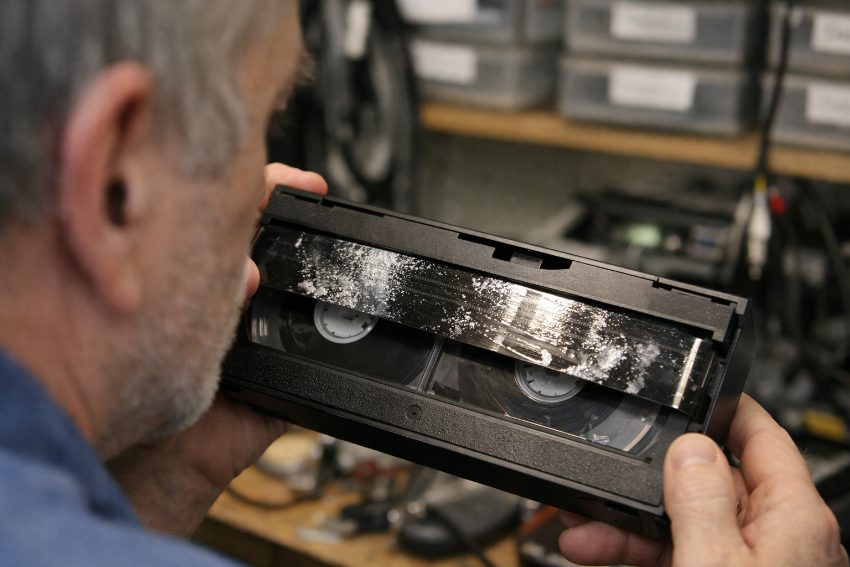 VHS tape showing oxide residue and sticky-shed syndrome from binder hydrolysis