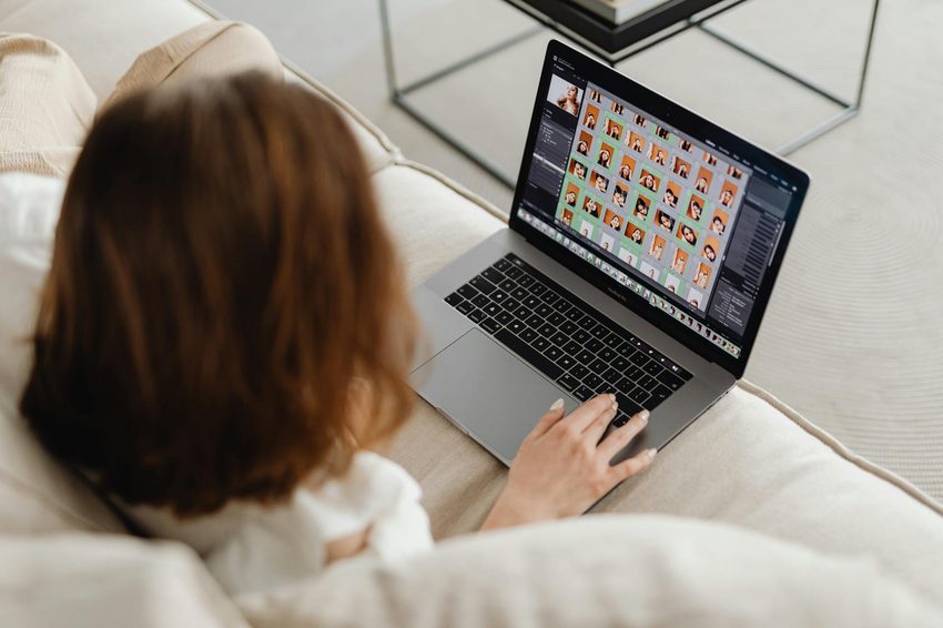 Woman reviewing an organized digital photo gallery on a laptop at home, the result of a well-organized photo digitization project