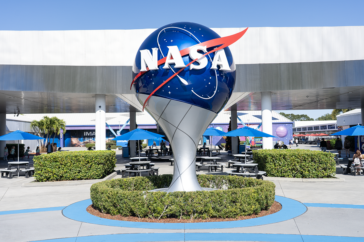 Multiple restored NASA artwork pieces hanging in Kennedy Space Center hallway