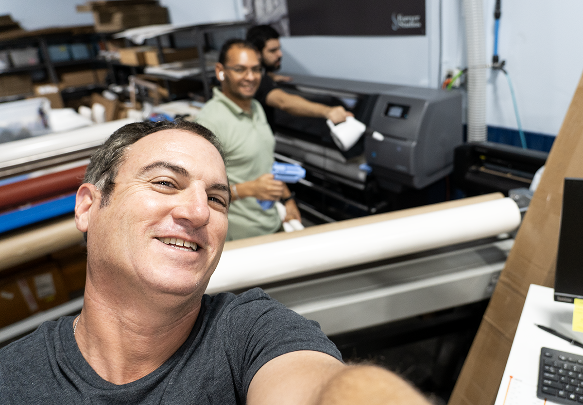 Forever Studios team reviewing final restored NASA artwork prints before client delivery and installation