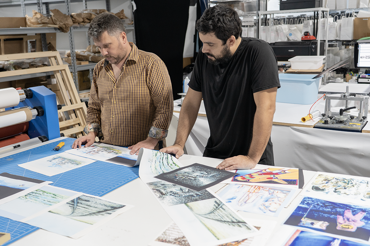Quality inspection of restored NASA artwork canvas prints at Forever Studios production facility